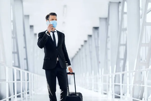 Empresário de sucesso passando pelo aeroporto, falando por telefone — Fotografia de Stock
