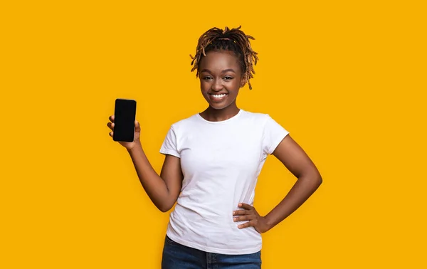 Senhora africana feliz mostrando novo telefone celular com tela em branco — Fotografia de Stock