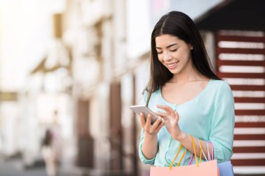 Çevrimiçi bankacılık. Genç Asyalı Kadın Alışveriş yaptıktan sonra Para Dengesini Akıllı Telefonla Kontrol Ediyor