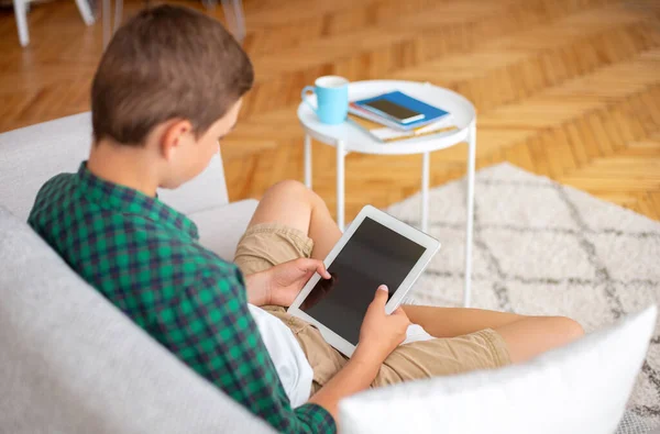 Adolescente sosteniendo tableta digital con pantalla vacía, interior del hogar — Foto de Stock