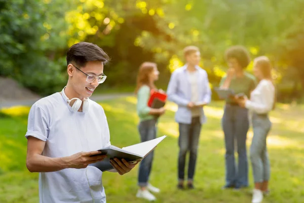 Happy Chinese Mężczyzna Student odpoczynku w kampusie po zajęciach, gospodarstwa skoroszyt — Zdjęcie stockowe