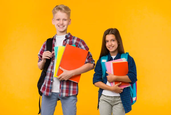 Lächelnde Teenager posieren mit Schulbüchern im Studio — Stockfoto