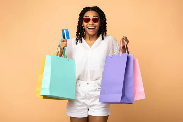 Ragazza africana su Shopping Holding carta di credito, sfondo Beige Studio — Foto Stock