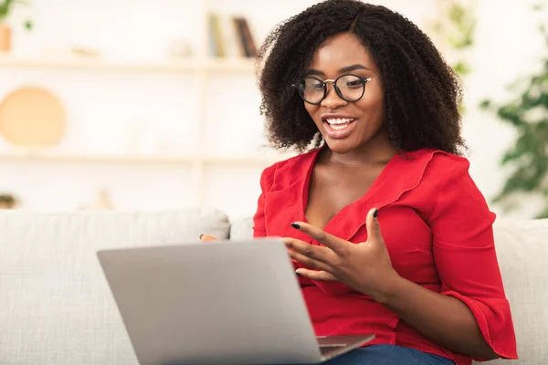 Ragazza felice utilizzando il computer portatile per videochiamata e agitando — Foto Stock