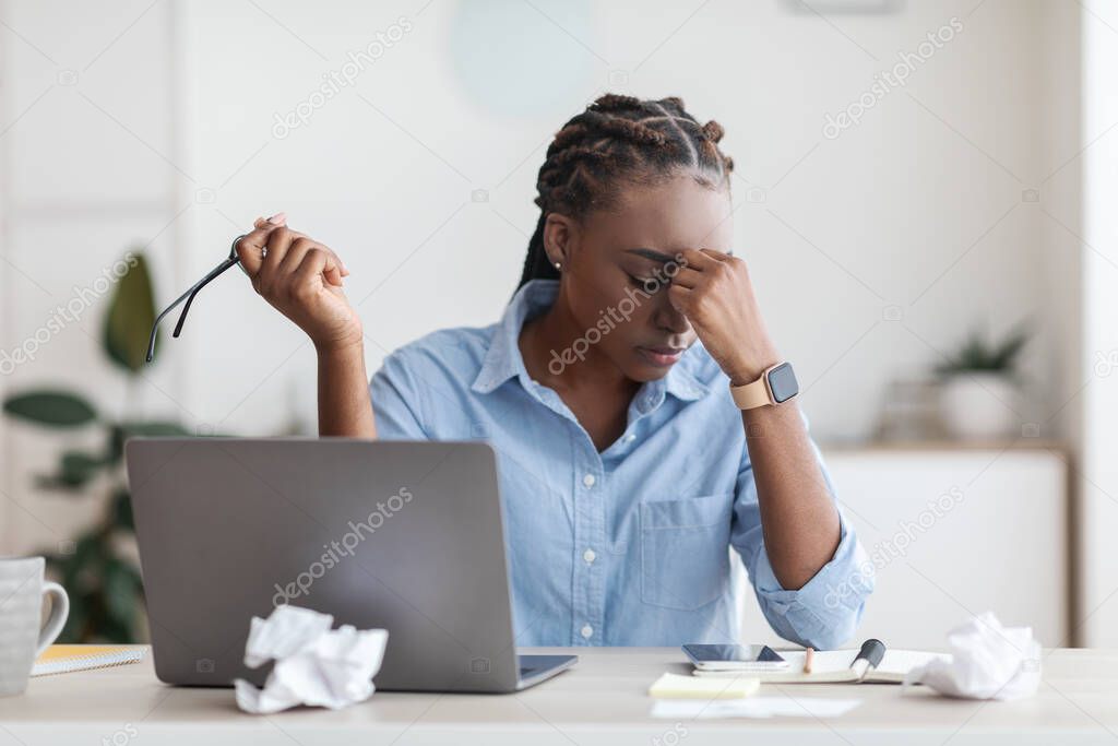 Deadline Stress. Overworked Black Female Entrepreneur Massaging Nosebridge At Workplace In Office