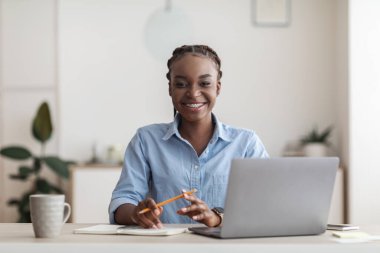 Ofisteki ilk gün. İş yerindeki masada oturan siyahi kadın stajyer.