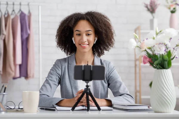 Mode blogger en moderne technologie. Vriendelijke vrouw met draadloze hoofdtelefoon maakt video voor blog — Stockfoto