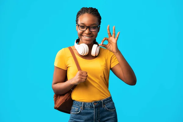 African Student Girl Gesturing OK Posing Over Blue Background — стокове фото