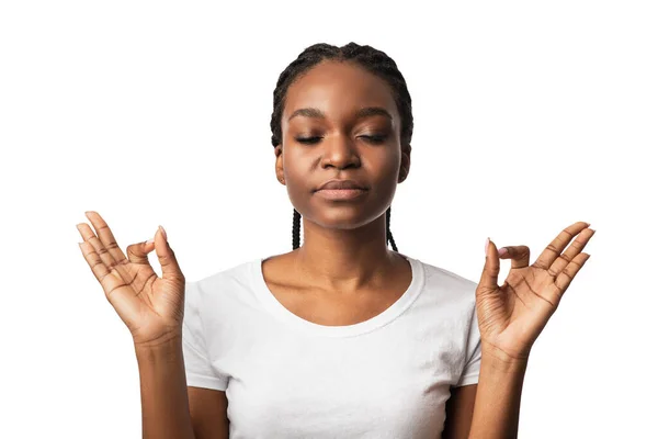 Pacífica chica negra meditando con los ojos cerrados sobre fondo blanco —  Fotos de Stock