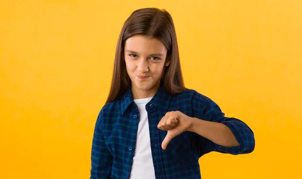 Young teenage girl showing thumbs down gesture — Stock Photo, Image