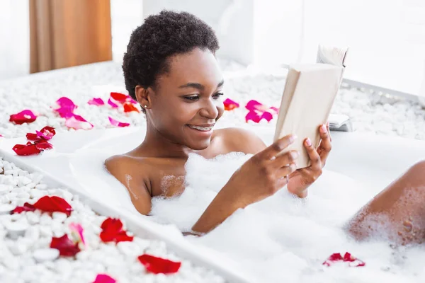 Weekend and relax. Happy girl reads book in bathroom with foam — Stock Photo, Image