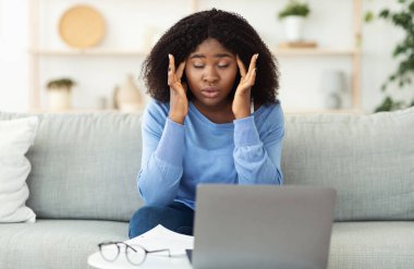 Yorgun Afrikalı Amerikalı menajer kişisel bilgisayarını kullanıyor.