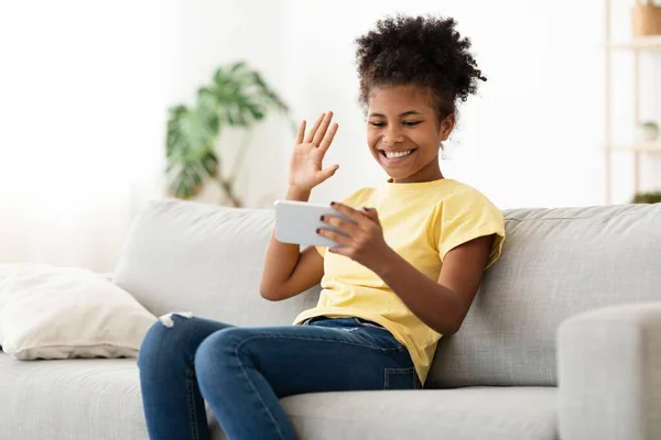 Akıllı telefonlu Afrikalı genç kız evde video görüşmesi yapıyor. — Stok fotoğraf