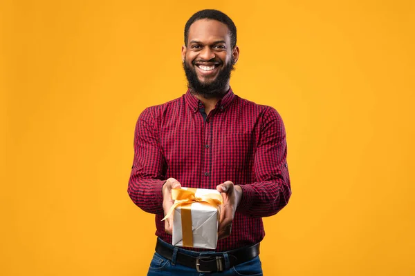 Gelukkig zwart man holding geschenk doos in studio — Stockfoto
