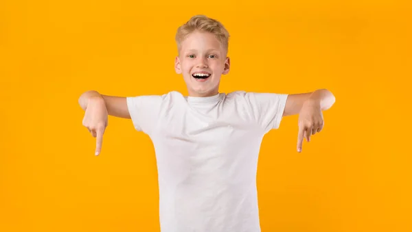 Szczęśliwy chłopiec wskazując palce w dół w przestrzeń kopiowania — Zdjęcie stockowe