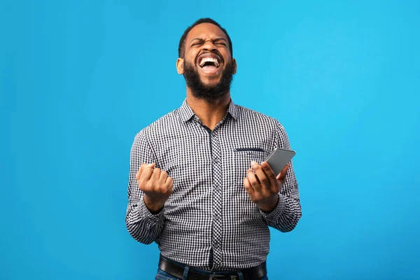 Opgewonden zwarte man met telefoon en gebaar — Stockfoto