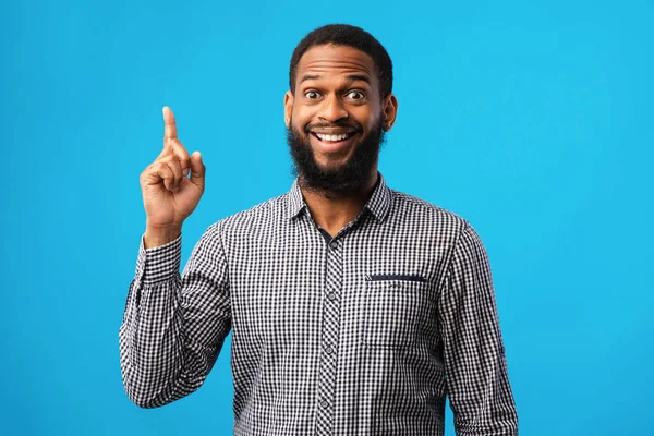 Emocionado chico negro teniendo una gran idea y apuntando hacia arriba — Foto de Stock