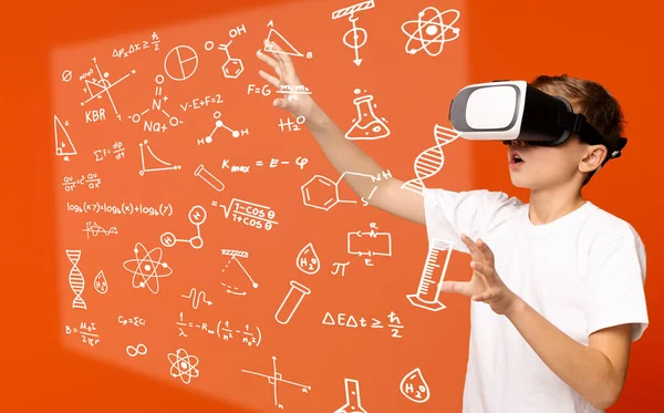 Adolescente usando óculos VR para estudar, fundo laranja — Fotografia de Stock