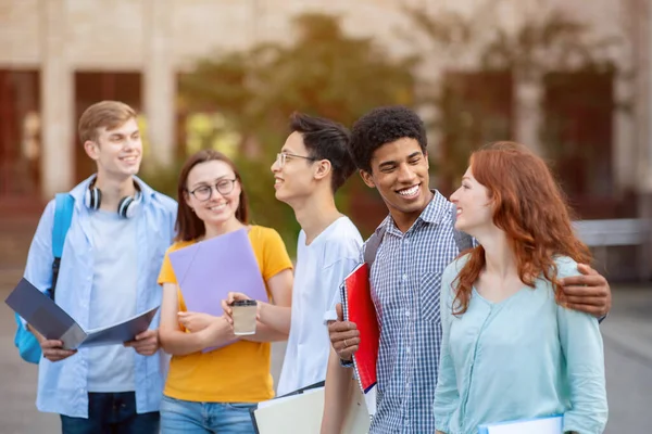 Cinco estudantes multirraciais caminhando juntos perto do campus — Fotografia de Stock