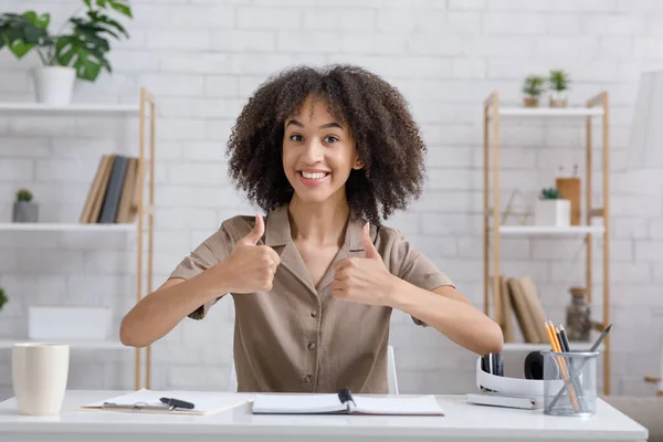 Work at home office. Happy african american woman showing thumbs up