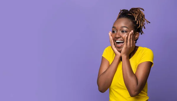 Menina africana incrível com as mãos nas bochechas olhando para o lado — Fotografia de Stock