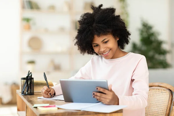 Menina adolescente feliz usando tablet digital estudando em casa — Fotografia de Stock