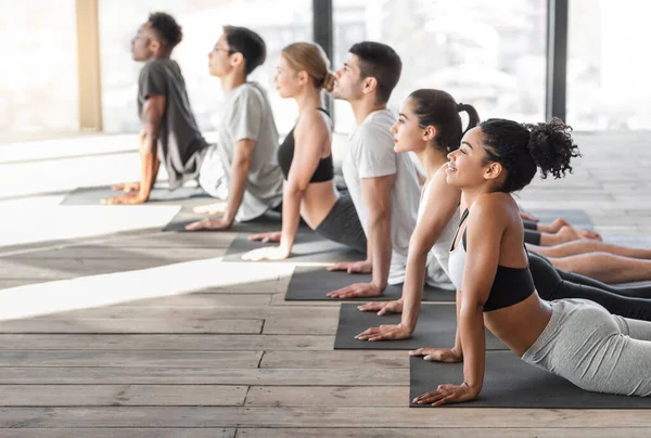 Cobra Pose. Jeune homme et femme faisant des exercices de yoga en studio ensemble — Photo