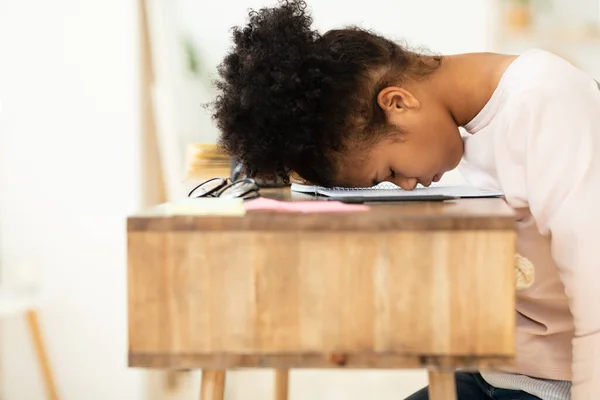 Overworked Africano menina descansando cabeça na mesa sentado dentro de casa — Fotografia de Stock