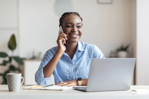 Imprenditrice nera che parla al cellulare sul posto di lavoro in ufficio, consulente cliente — Foto Stock
