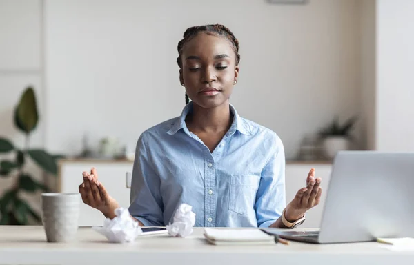 Coping With Stress At Work. Young African Businesswoman Meditating In Office