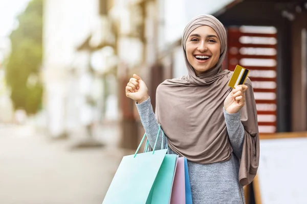 Renkli alışveriş çantaları ve kredi kartları olan hoş Müslüman kız. — Stok fotoğraf