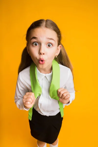 Verrast elementair student meisje op zoek naar camera poseren in Studio — Stockfoto