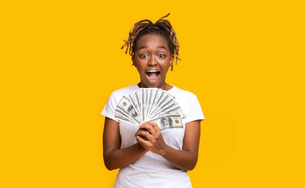 感情的な黒の女性保持お金で黄色の背景 — ストック写真