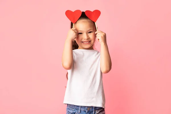 Asiático menina segurando papel corações em mãos — Fotografia de Stock