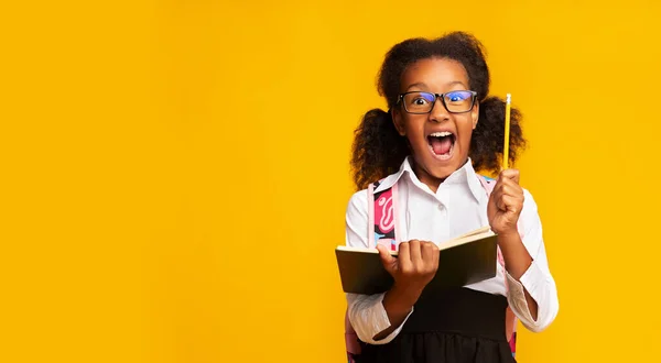 Σχολείο κορίτσι έχοντας ιδέα κρατώντας μολύβι και βιβλίο στο στούντιο — Φωτογραφία Αρχείου