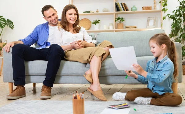 Parents Looking At Daughters Sketch Relaxing Sitting At Home — Stock Photo, Image