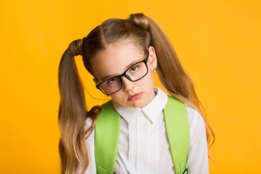 Aşırı çalışan öğrenci, sarı arkaplanda kamera pozu veriyor.