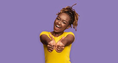 Memnuniyetle Afro-Amerikalı kız başparmağını kaldırıyor.