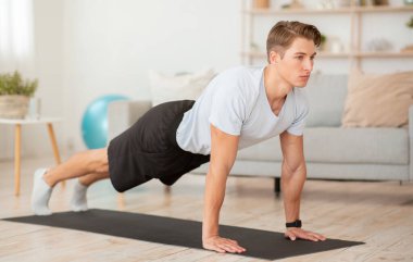 Evde kal, COVID-19 salgını sırasında kendine dikkat et. Atletik adam kalas yapıyor.