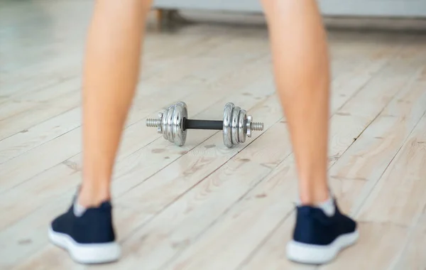 Strength training during quarantine. Man in sneakers stands near dumbbell and cup for shakes — Stock Photo, Image