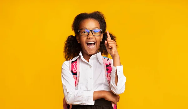 Alegre escuela niño chica apuntando dedo arriba de pie, estudio disparo — Foto de Stock