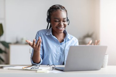 Video konferansı. Dost canlısı siyahi kadın bilgisayarını ofiste arıyor.
