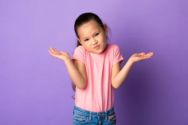 Confuso perplesso asiatico bambino scrollando le spalle a studio — Foto Stock