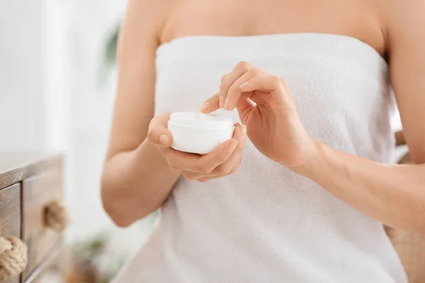 Close-up van de vrouw verpakt in handdoek vasthouden pot met room — Stockfoto