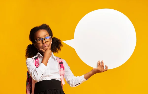 Colegiala afroamericana pensativa sosteniendo la burbuja del habla, fondo amarillo, burla —  Fotos de Stock