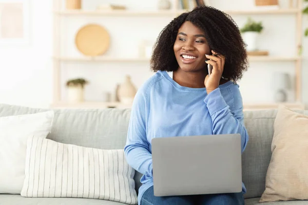 Menina feliz usando laptop, falando no telefone — Fotografia de Stock