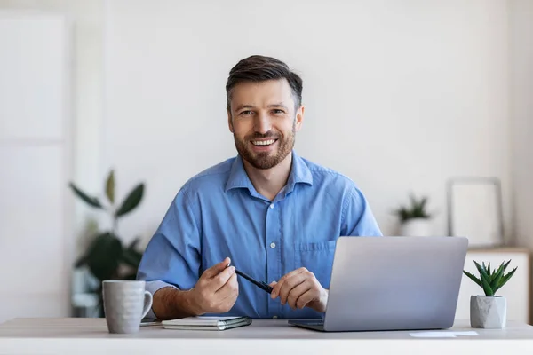 Rekrutierungskonzept. Freundlicher männlicher Personalmanager sitzt am Arbeitsplatz im modernen Büro — Stockfoto