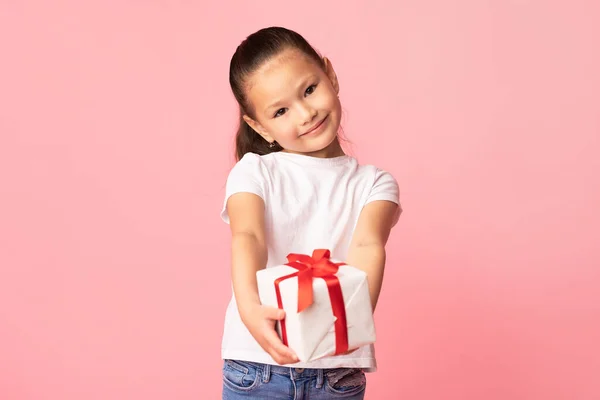 Chica feliz dándote caja de regalo en el estudio — Foto de Stock