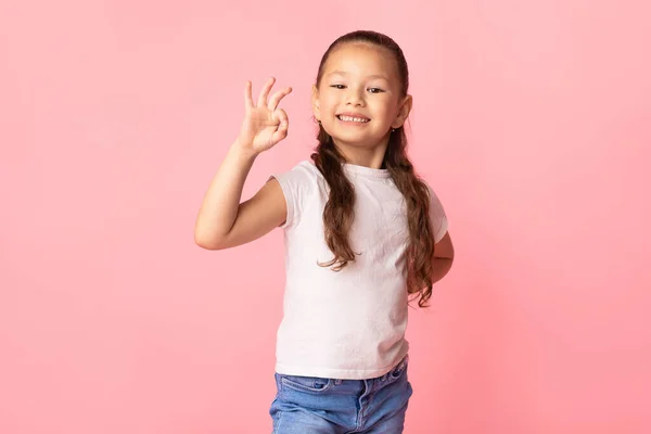 Asiática chica mostrando ok gesto y sonriendo — Foto de Stock