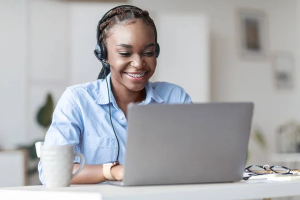 Operadora de línea directa. Mujer africana trabajadora de call center en consultoría de auriculares cliente en línea —  Fotos de Stock